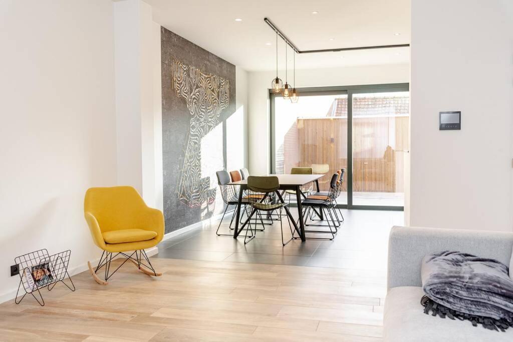 a living room with a table and chairs at Boonuz guesthouse, luxe duplex vakantiehuis in centrum Ieper met privé lounge terras en IR sauna in Ieper