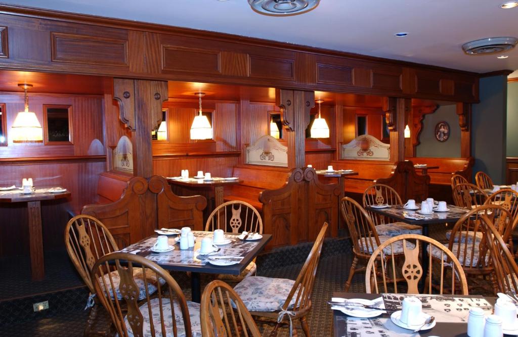 a dining room with tables and chairs in a restaurant at Auberge Lakeview Inn in Lac-Brome