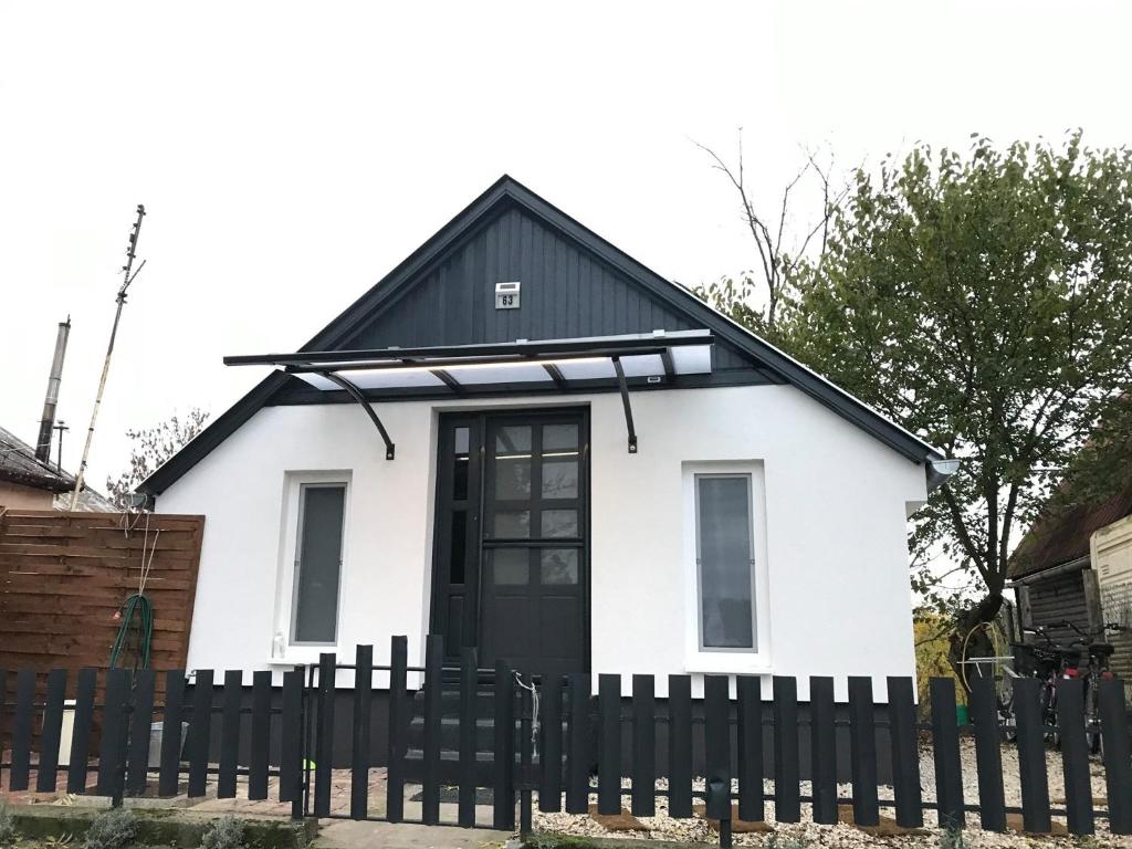 a house with a black and white fence at Futrinka Vendégház in Baja