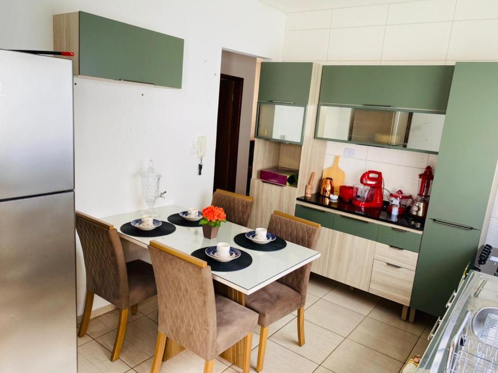 Il comprend une cuisine équipée d'une table, de chaises et d'un réfrigérateur. dans l'établissement Casa para temporada, à Buriti