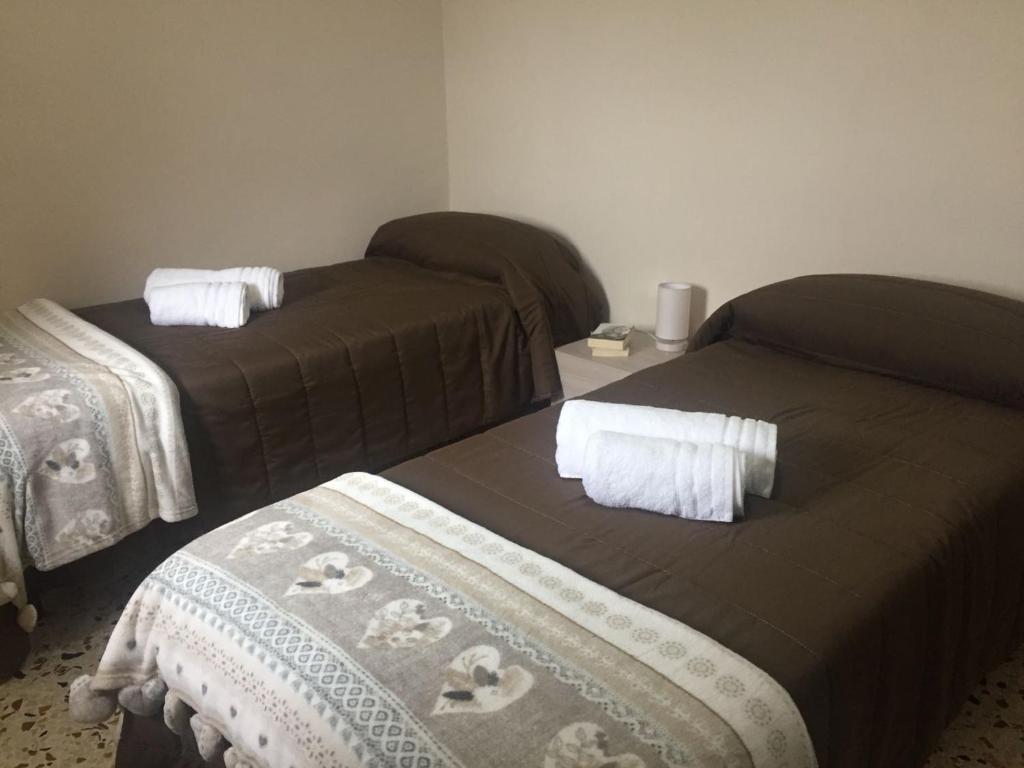 een kamer met 2 bedden en witte handdoeken. bij Casa Belvedere in Sambuca di Sicilia