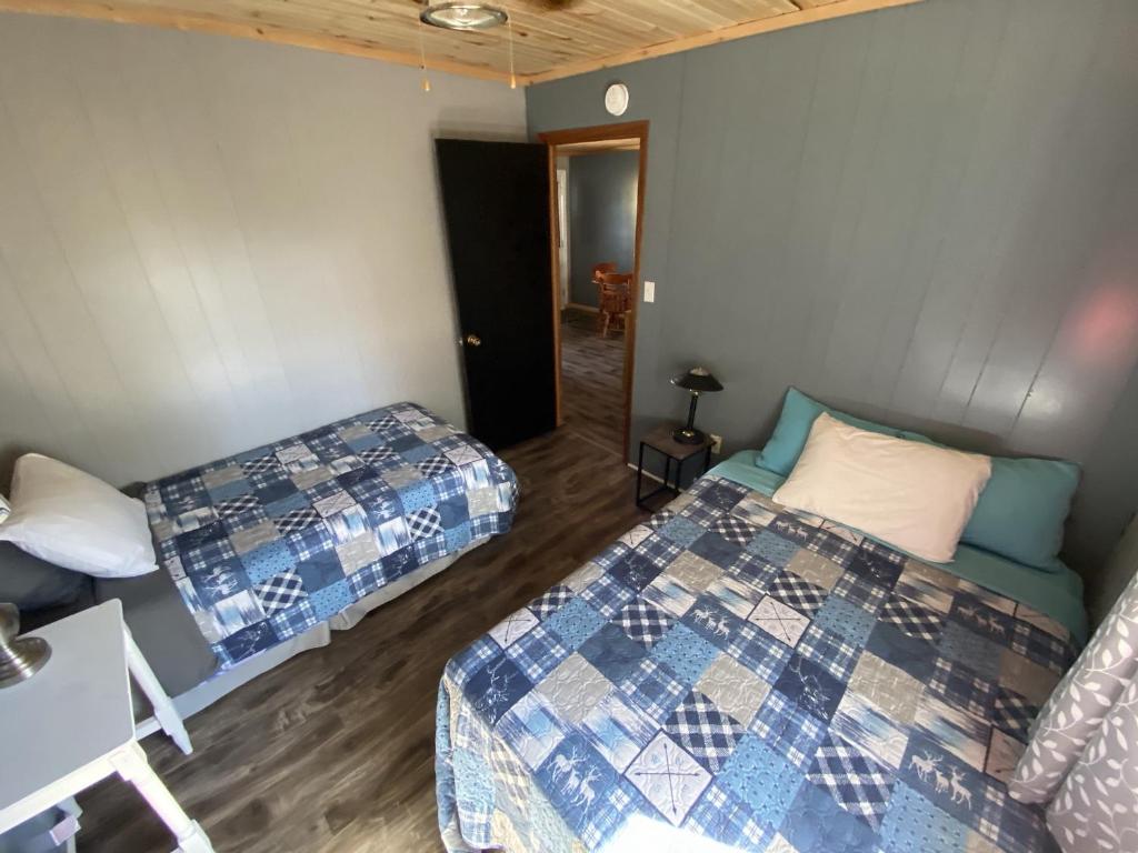 a room with two beds and a hallway at The Pines Motel and Cottages in Rustico
