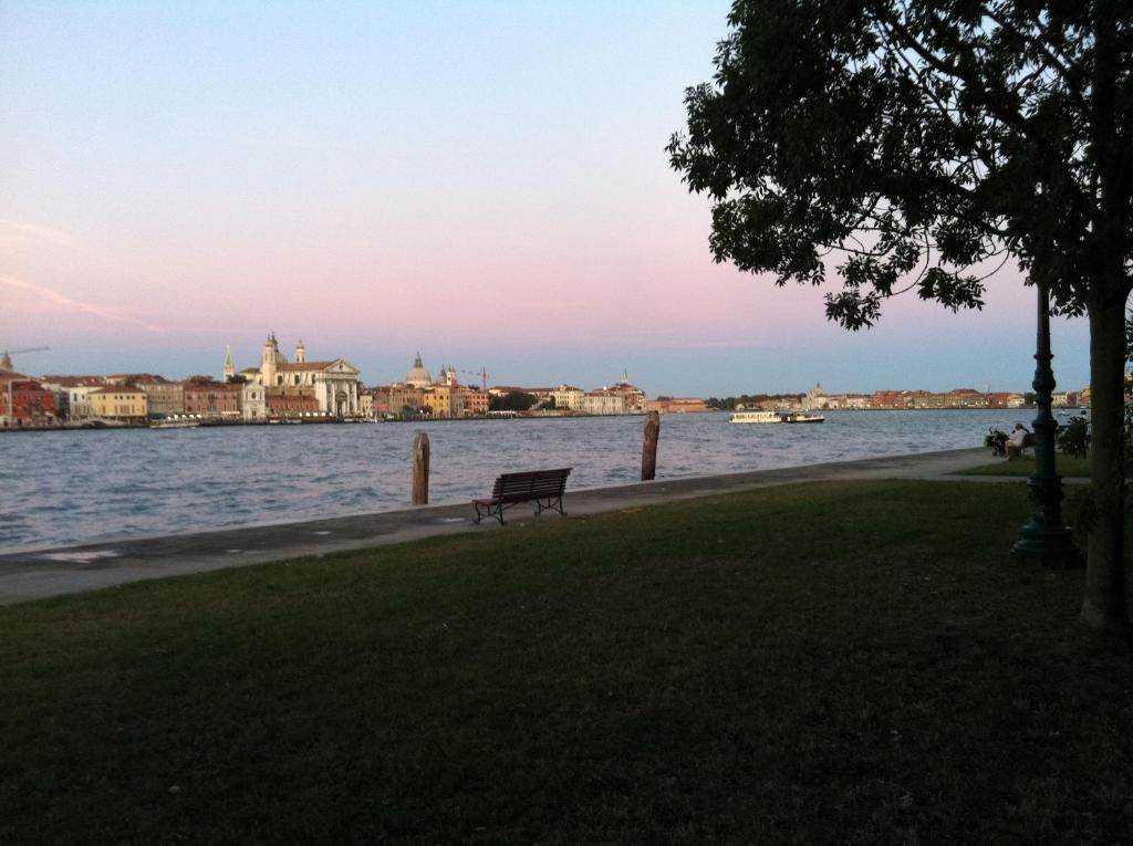 un banco del parque sentado junto a un cuerpo de agua en Venice Home, en Venecia