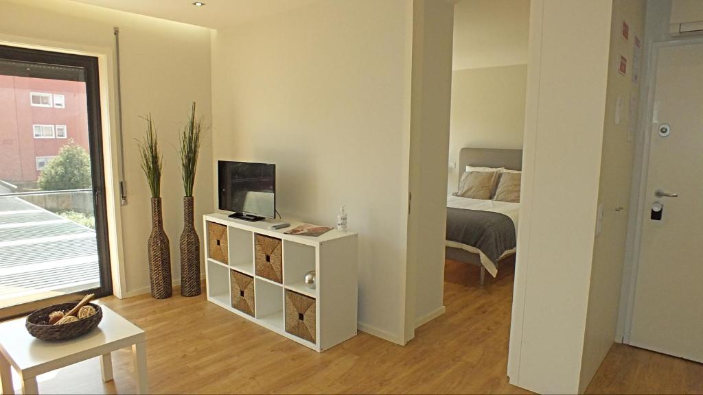a room with a bedroom with a bed and a table at Valadim Flats_2T in Porto