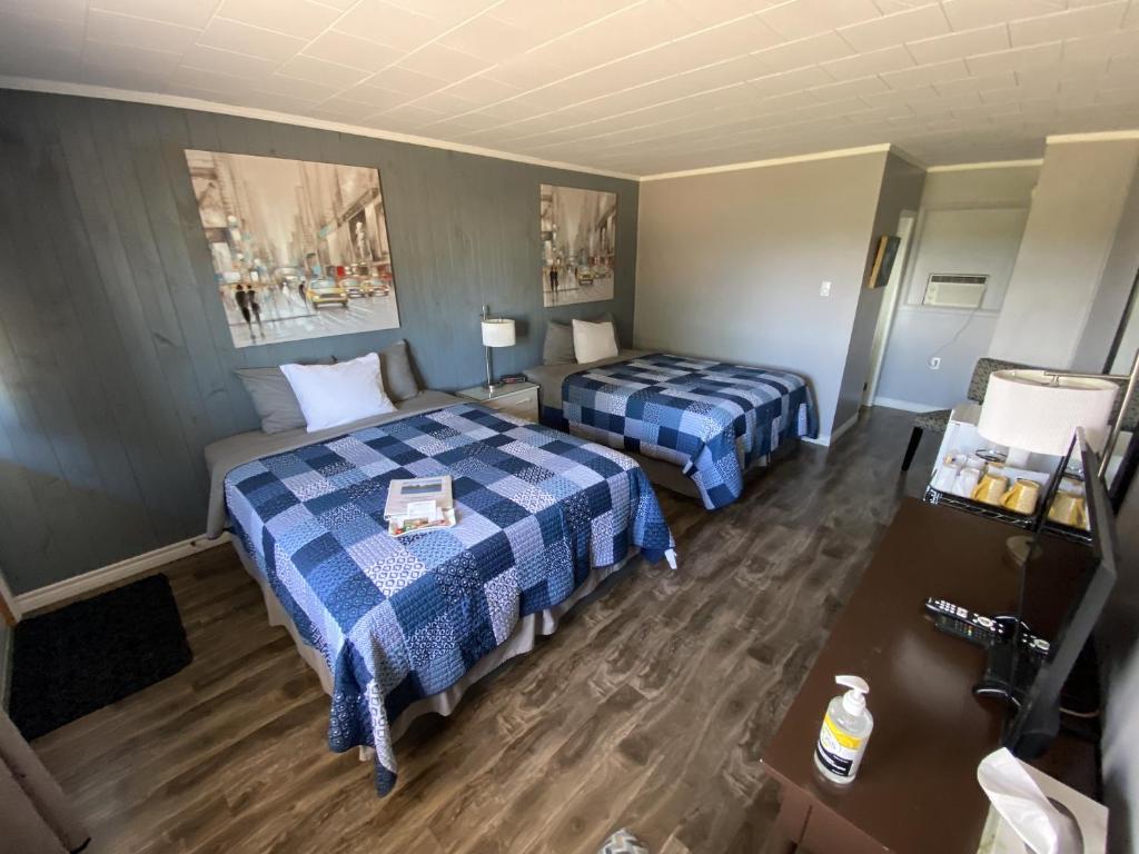 a hotel room with two beds and a camera at The Pines Motel and Cottages in Rustico
