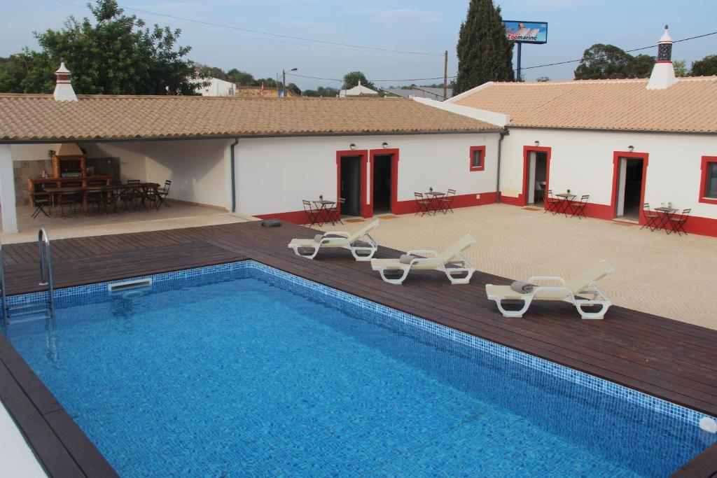 einen Pool mit Liegestühlen und ein Haus in der Unterkunft Quinta do Sr. Cabrita in Albufeira