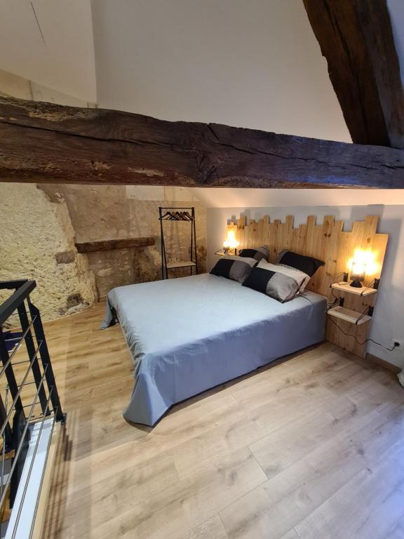 a bedroom with a large bed and a wooden floor at Les Logis du rempart in Loches