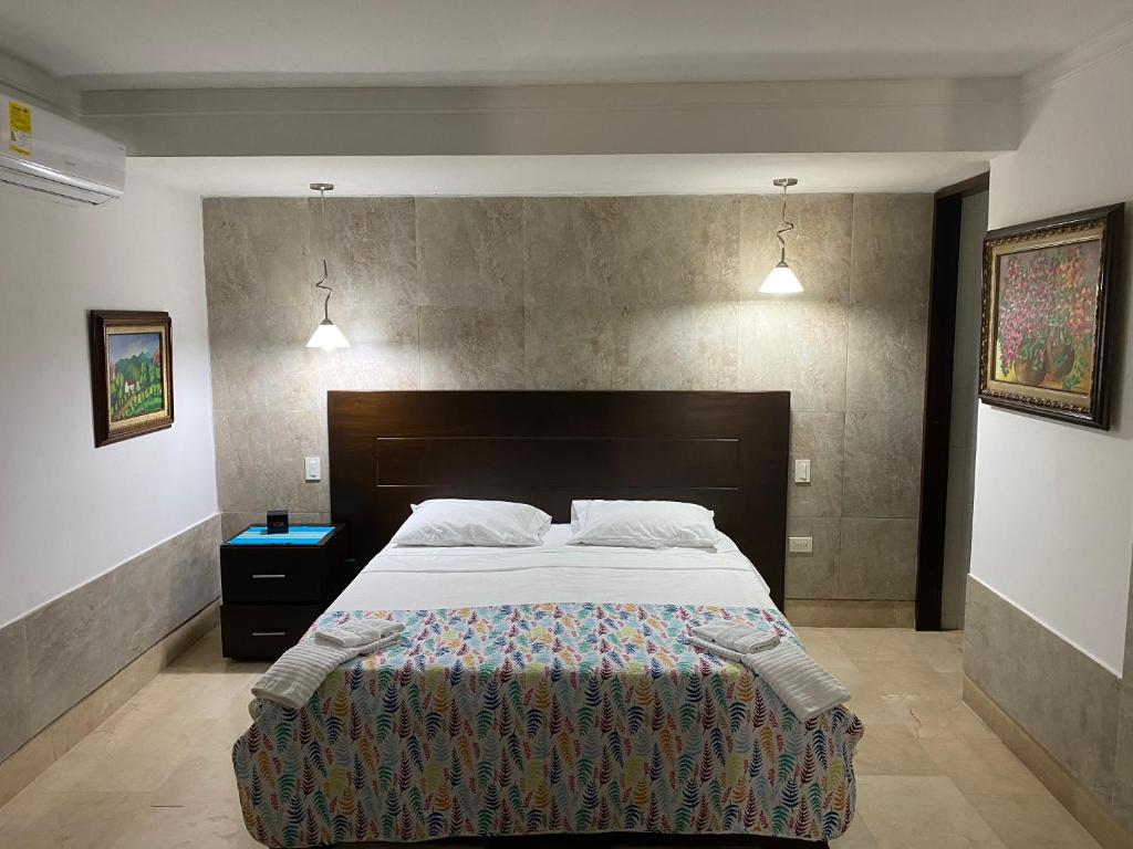 a bedroom with a large bed and two lights at Apartaestudio amplio in Barranquilla