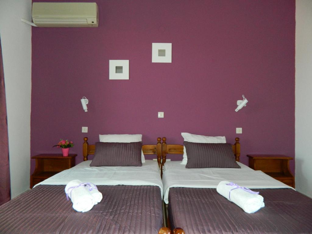 a bedroom with a bed with a purple wall at Roseberry Studios in Faliraki