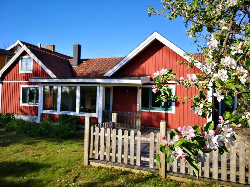 a red house with a fence in front of it at Wannborga Destilleri in Borgholm