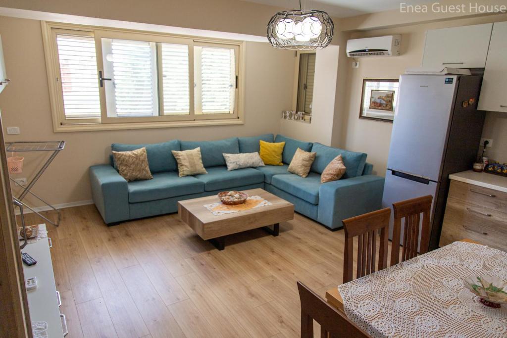 a living room with a blue couch and a table at Enea’s guest house in Vlorë