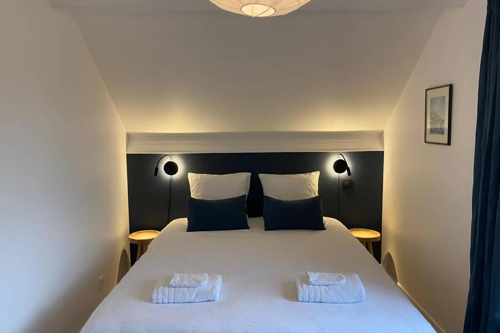 a bedroom with a large white bed with two pillows at Gîte le 44 - au calme avec jardin, proche de Namur in Namur