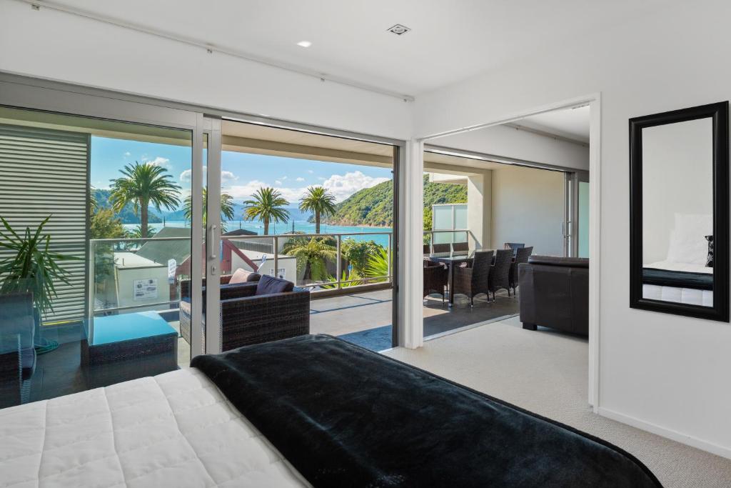 een slaapkamer met een bed en uitzicht op de oceaan bij Luxury Waterfront Apartment - Abode No 1 in Picton