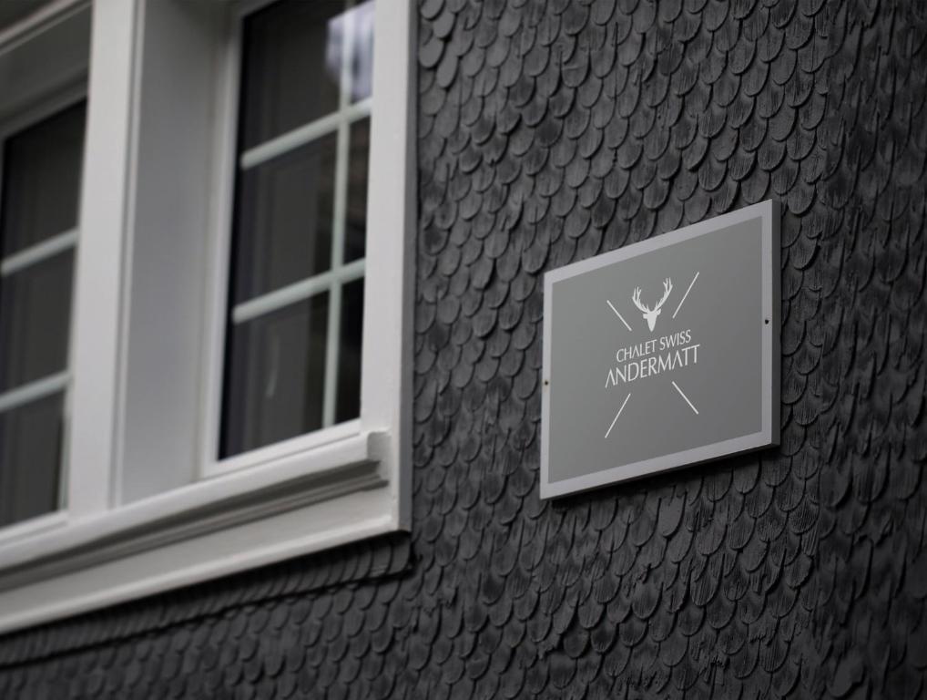 a sign on the side of a building with a window at Chalet Swiss Andermatt in Andermatt
