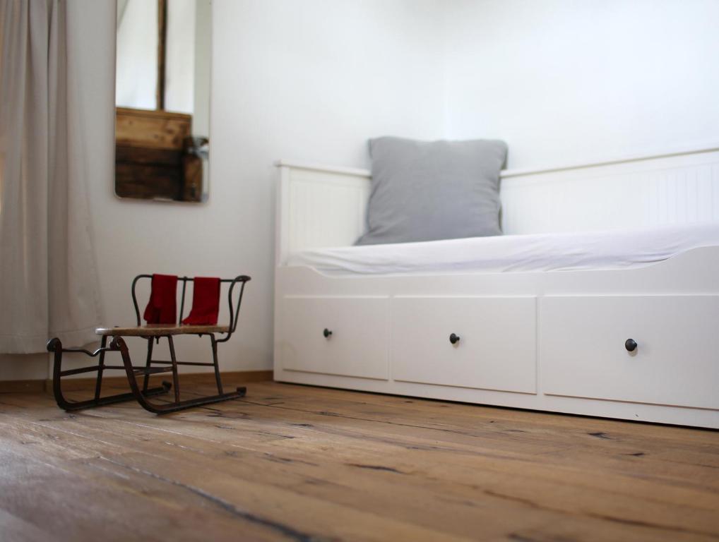 a bedroom with a white bed and a chair at Chalet Swiss Andermatt in Andermatt