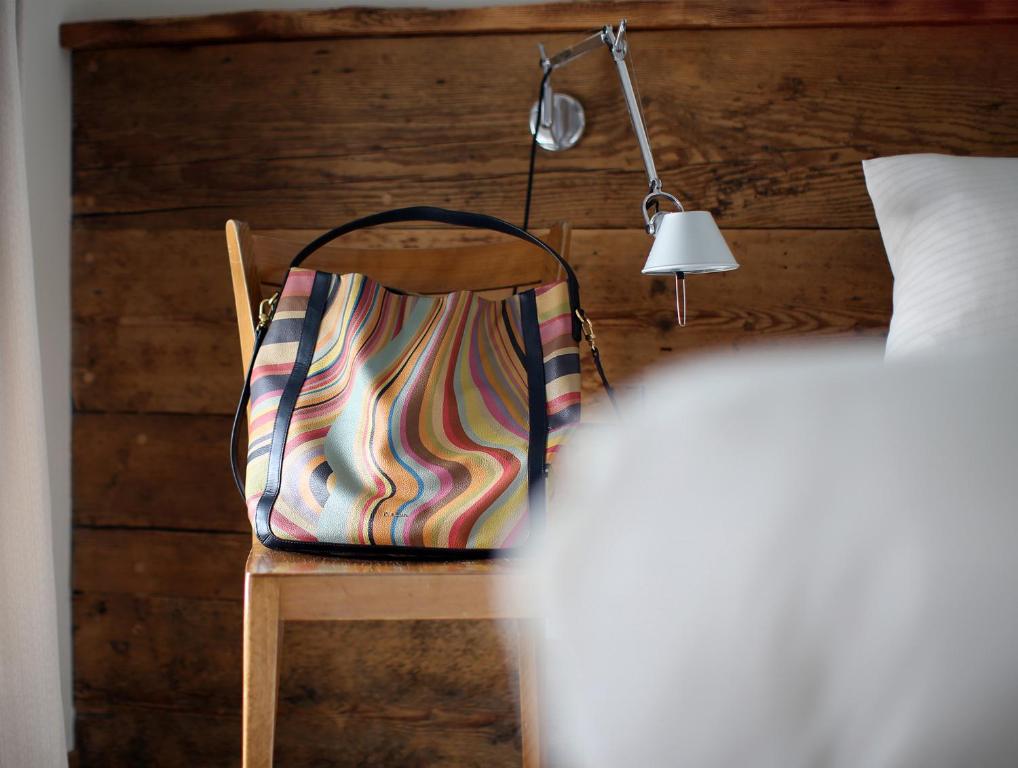 a bag sitting on a chair next to a bed at Chalet Swiss Andermatt in Andermatt