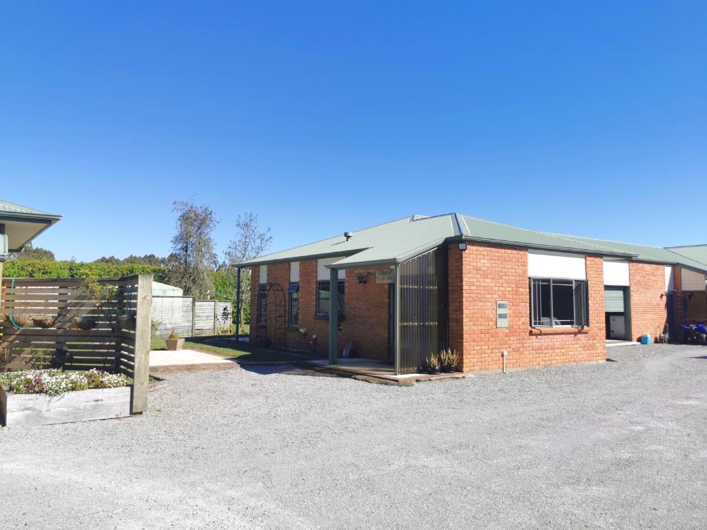 a red brick building with a metal roof at Ridgetop cottage in Wairakei