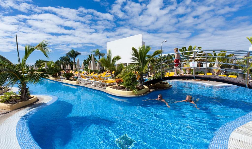 ein Pool in einem Resort mit Menschen, die darin schwimmen in der Unterkunft Paradise Park Fun Lifestyle Hotel in Los Cristianos