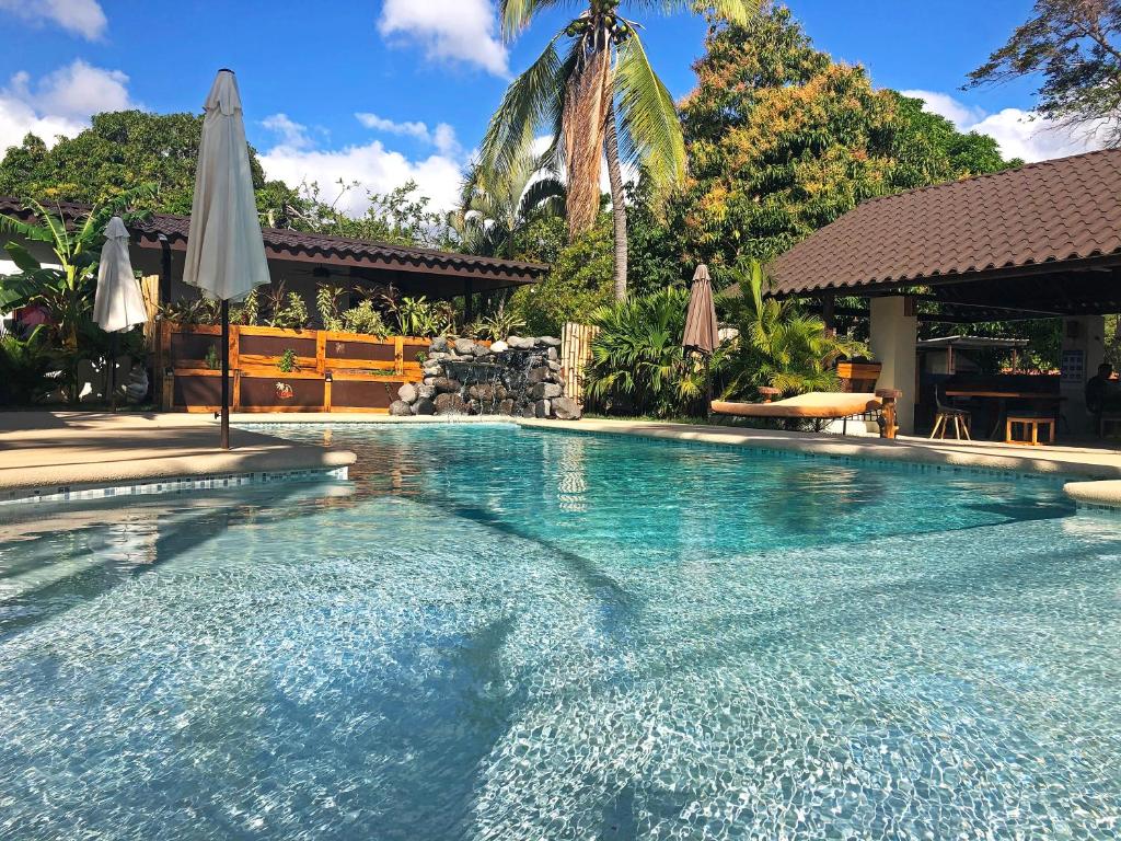 uma grande piscina com um guarda-sol e uma piscina em Casa Swell Coronado em Playa Coronado