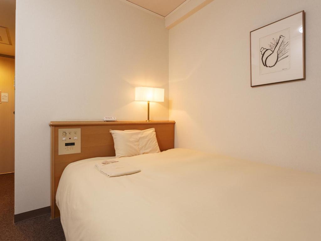 Postel nebo postele na pokoji v ubytování AkishimaStationHotel TOKYO