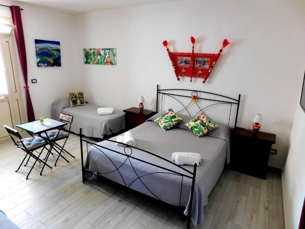 una camera con letto, tavolo e sedie di Sicilia Room a Carrozziere