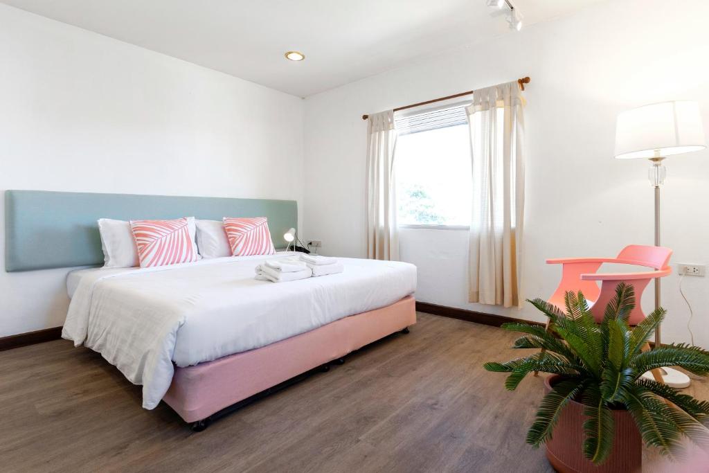 Un dormitorio con una cama grande y una maceta en Parasol Inn Chiang Mai Old City Hotel - SHA Plus en Chiang Mai