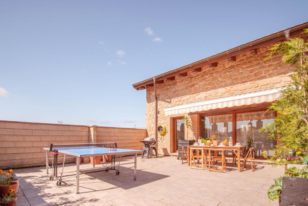 a ping pong table on a patio with a building at Casa rural Izargi in Mendigorría