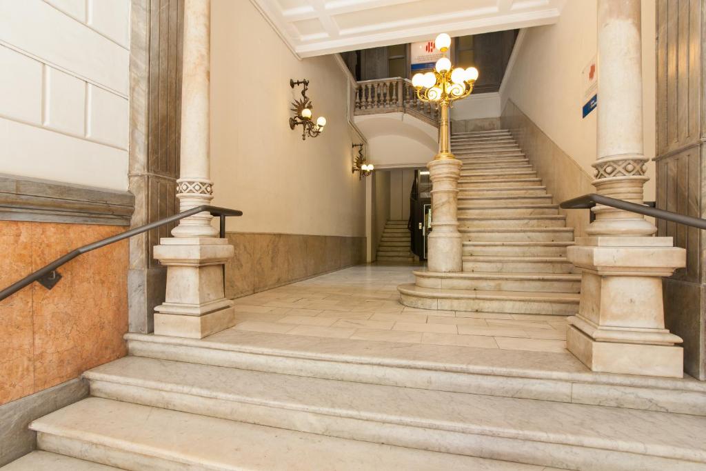 una escalera en un edificio con columnas y un poste en Rambla Suites, en Barcelona