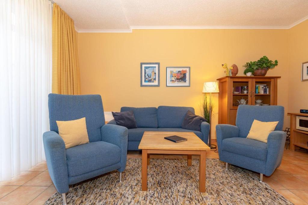 キュールングスボルンにあるHaus-Atlantik-Wohnung-0-12-619のリビングルーム(青い椅子2脚、テーブル付)
