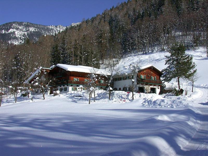 a house in the snow in front of a mountain at Ferienwohnung Malerlehen in Schönau am Königssee