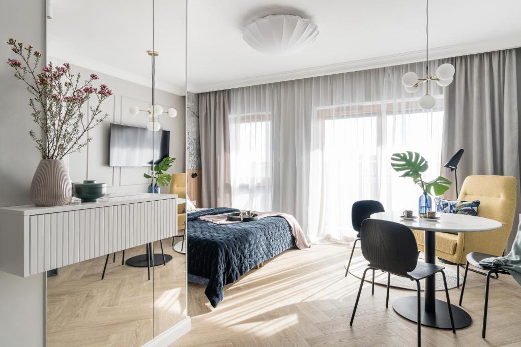 um quarto e uma sala de estar com uma cama e uma mesa em Downtown Apartments Riverside Nadmotławie - Parking, Sauna & Gym em Gdańsk