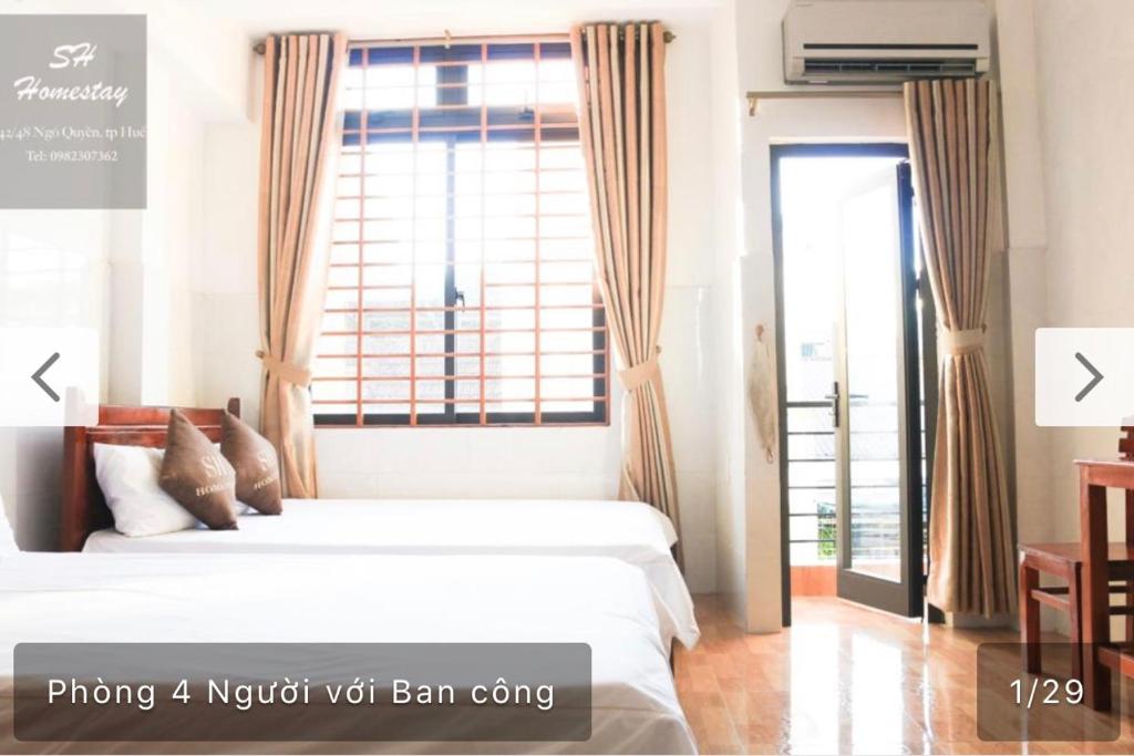 - une chambre avec 2 lits et une grande fenêtre dans l'établissement SH Hotel, à Hue
