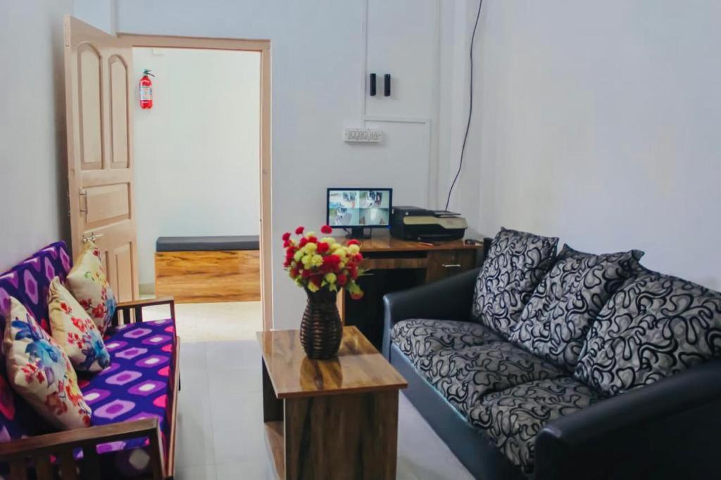- un salon avec un canapé et une table fleurie dans l'établissement Zcube Andaman, à Port Blair