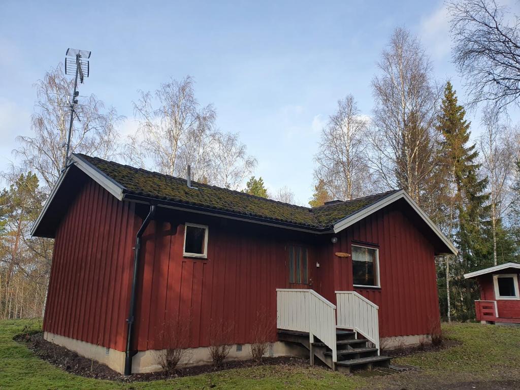 a red barn with a staircase in a field at Sjöstuga Vätö in Harg