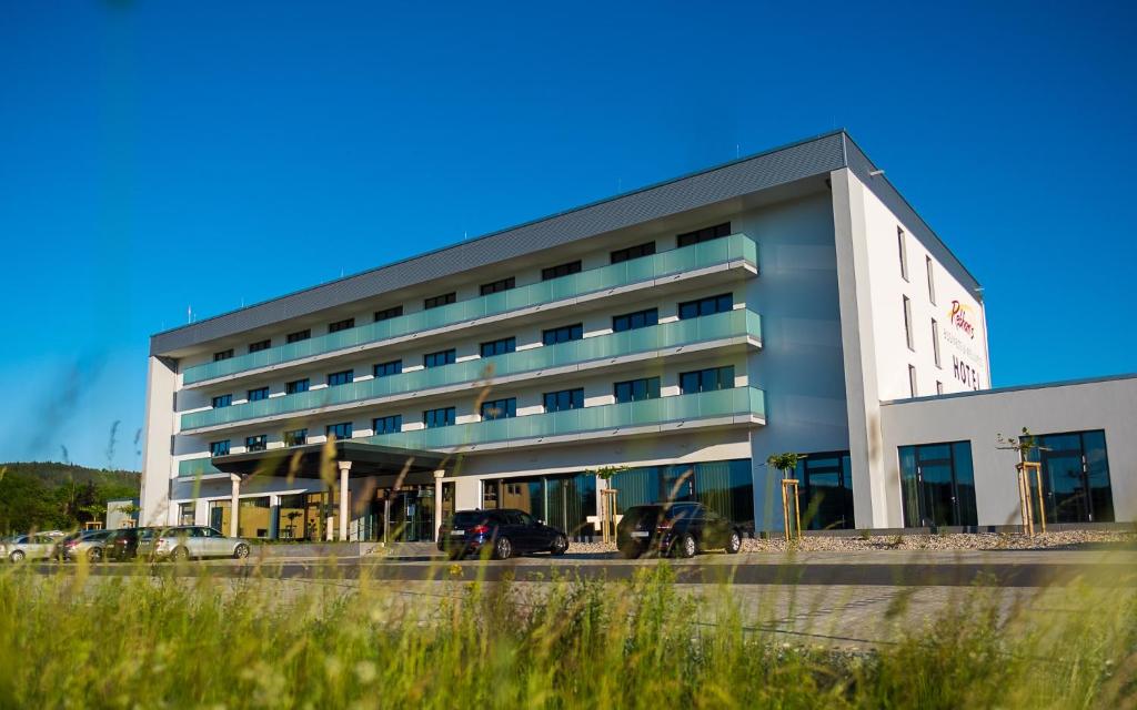 un edificio con coches estacionados frente a él en Rebhan's Business und Wellness Hotel, en Neukenroth