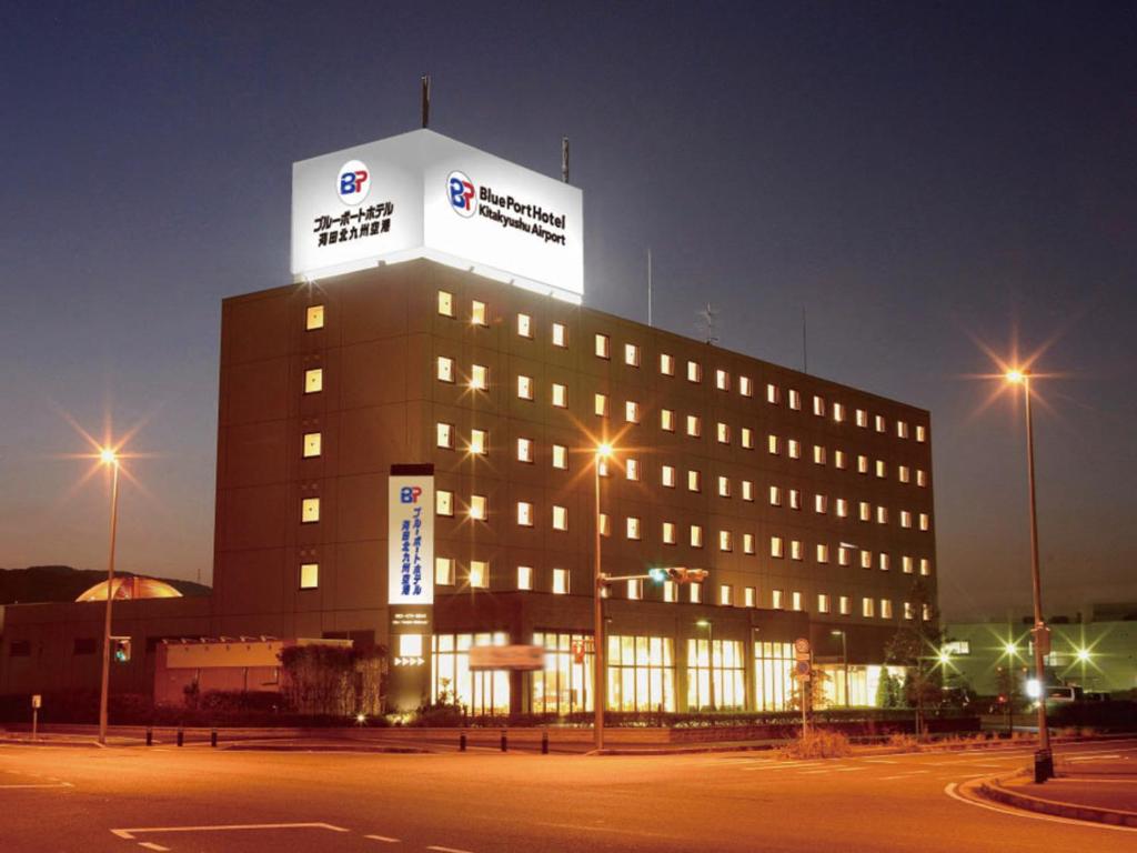 a building with a sign on the top of it at Blue Port Hotel Kitakyushu Airport in Kanda