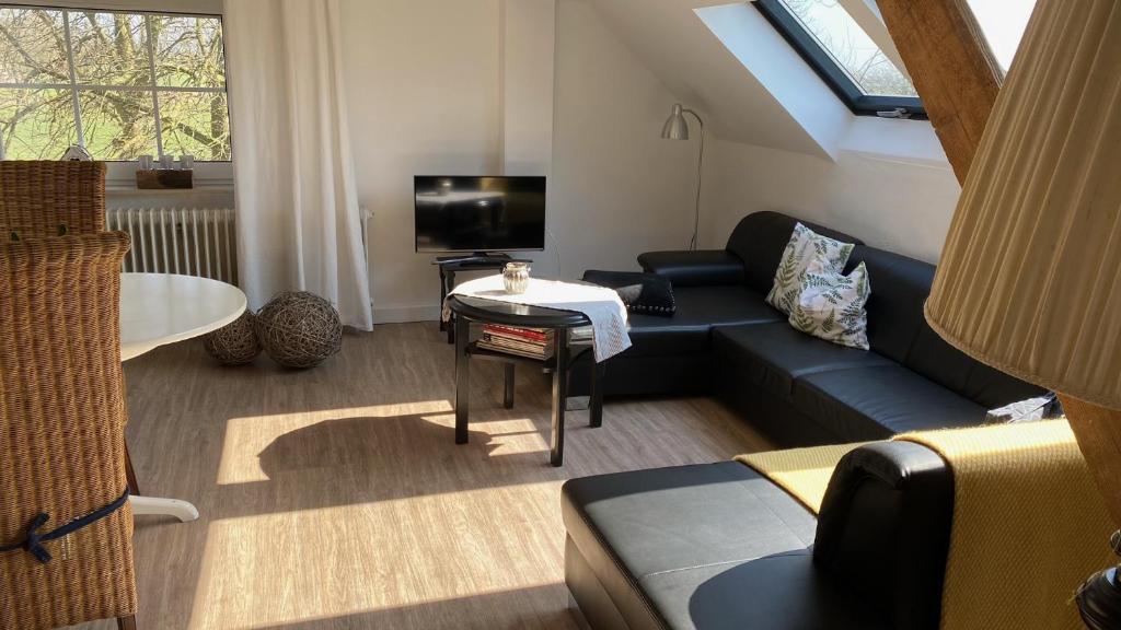 un soggiorno con divano blu e TV di Lichtpüntje a Norden