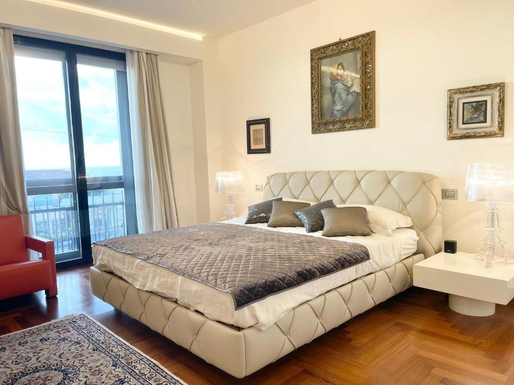 una camera con un grande letto e una grande finestra di Appartamento fronte mare con parcheggio privato a Viareggio