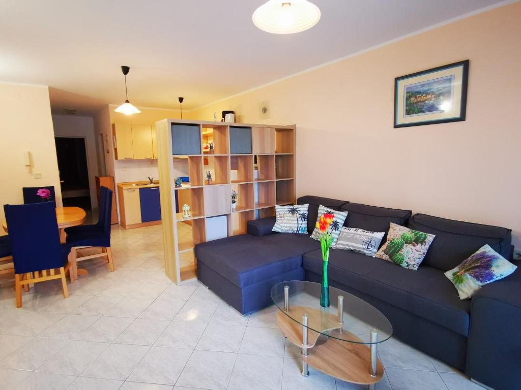 a living room with a blue couch and a table at Apartment Mirna in Baška