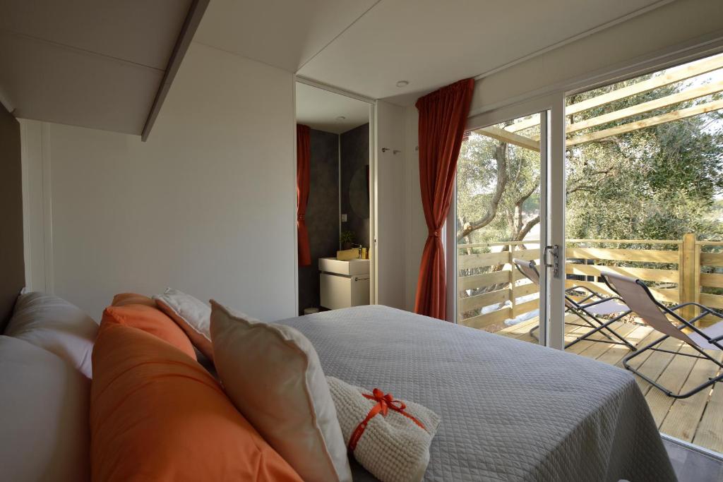a bedroom with a bed and a sliding glass door at Campeggio della Colombaia in Padenghe sul Garda