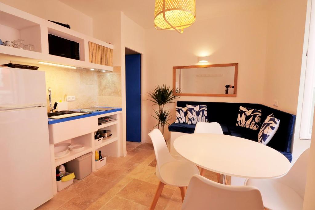 a kitchen and dining room with a white table and chairs at Les Petites Cyclades in Biarritz
