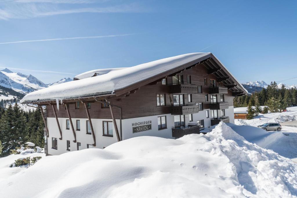 een met sneeuw bedekt gebouw met een berg sneeuw bij Haus Kreidl - Top 31 in Königsleiten