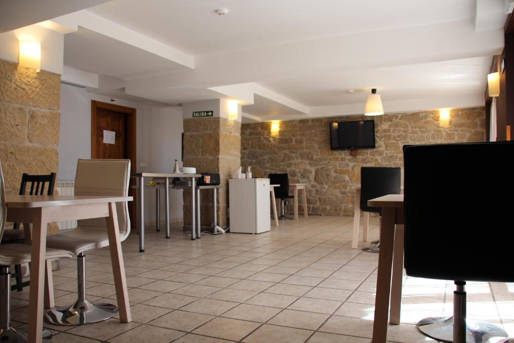 un comedor con mesas, sillas y una pared en Hospedaje Nuestra Señora de Ujue, en Tafalla