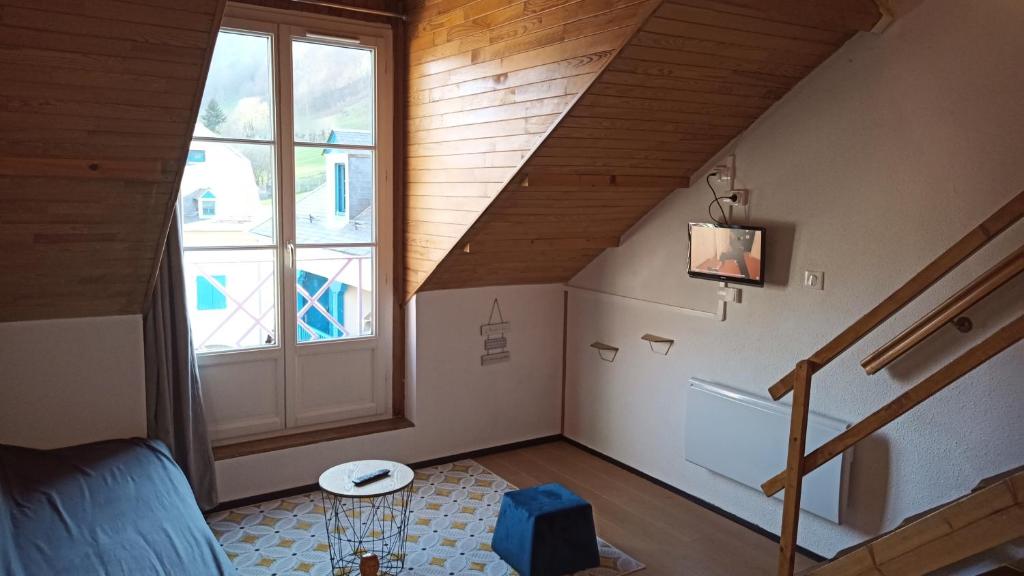 Cette chambre mansardée dispose d'un escalier et d'une fenêtre. dans l'établissement Appartement Sainte Marie de Campan - Résidence le Vieux Village, à Sainte-Marie-de-Campan