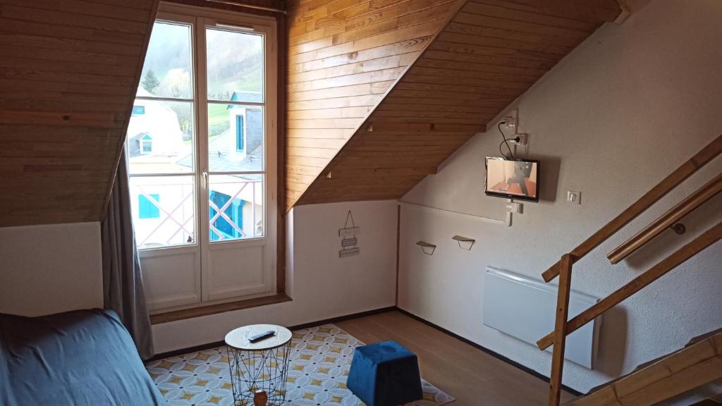 an attic room with a staircase and a window at Appartement Sainte Marie de Campan - Résidence le Vieux Village in Sainte-Marie-de-Campan
