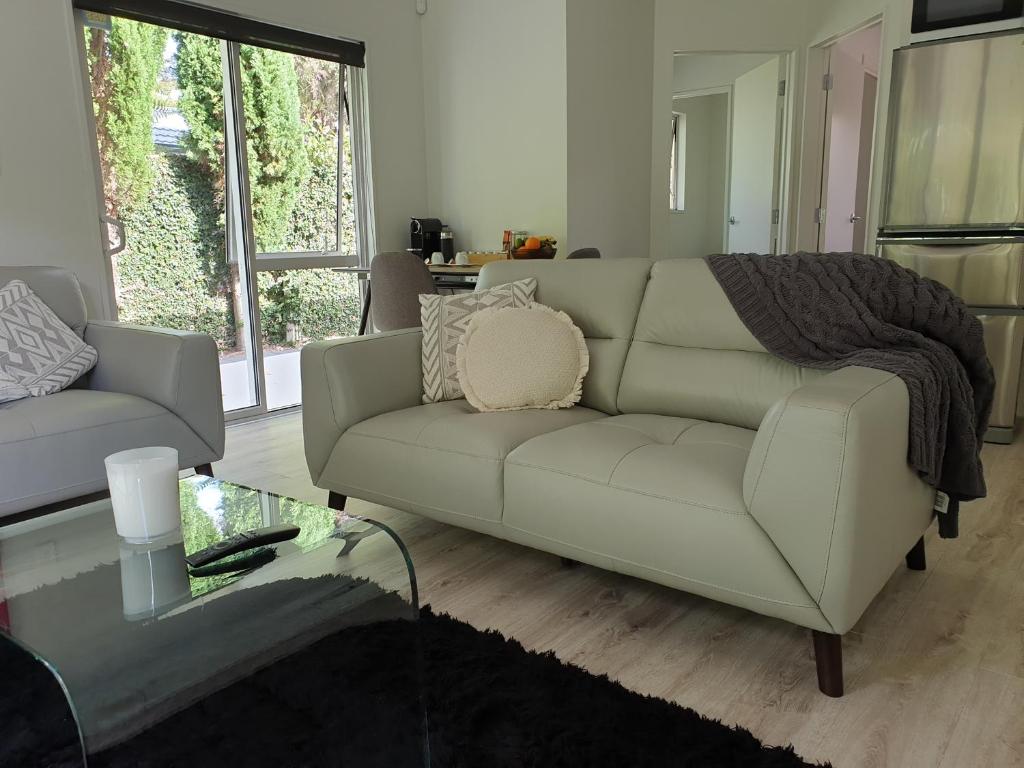 a living room with a couch and a glass table at Robyn's Retreat in Hamilton