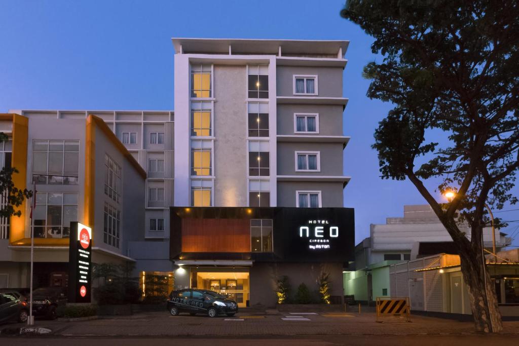 a building with a car parked in front of it at Hotel NEO Cirebon by ASTON in Cirebon