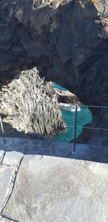 a rock cave with the water in front of it at La graciosa in Costa Del Silencio