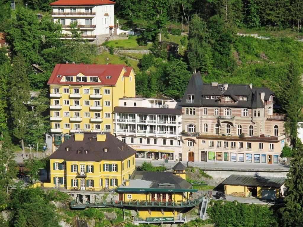eine Gruppe gelber Gebäude auf einem Hügel in der Unterkunft Haus Lothringen by AlpenTravel in Bad Gastein