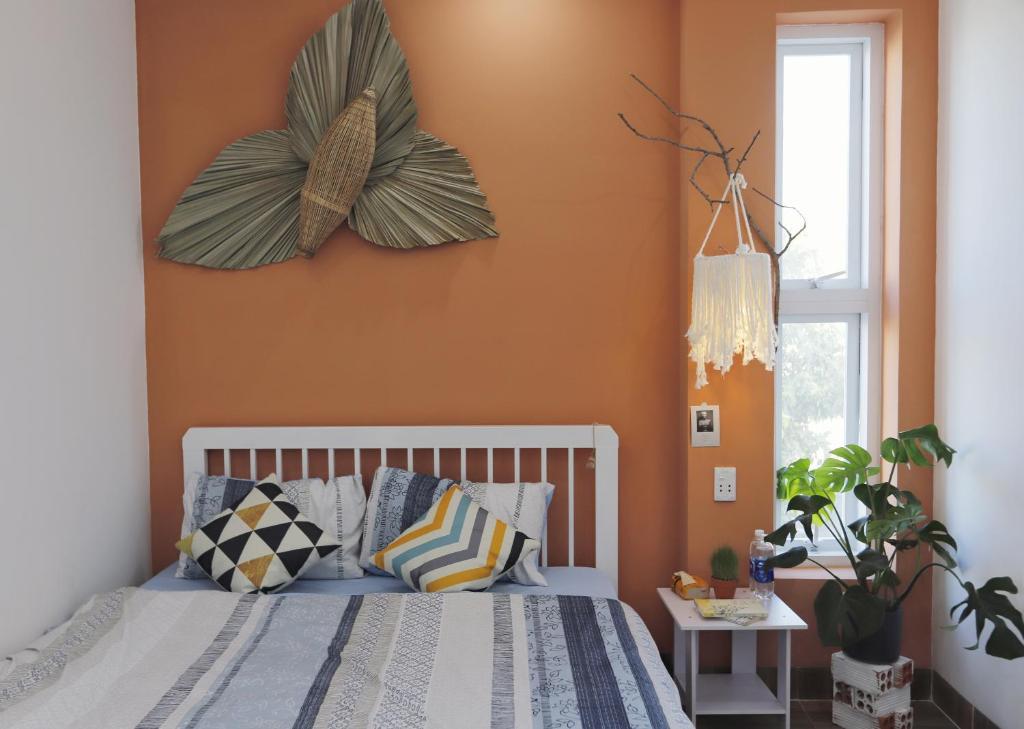 a bedroom with orange walls and a bed with pillows at Cube homestay Phan Rang cách biển 300m to the beach in Phan Rang